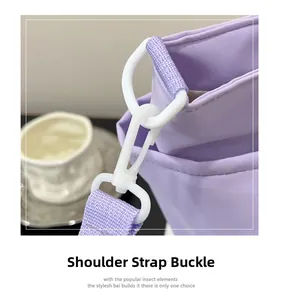 Detail of lavender canvas bag featuring white plastic shoulder strap hardware and D-ring