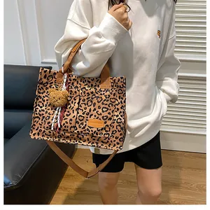 Leopard print canvas tote bag with adjustable brown strap and plush bear charm