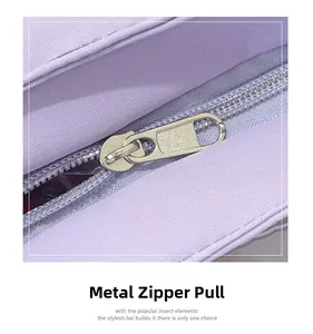 Detail of high-quality metal zipper pull on a light purple fabric crossbody bag