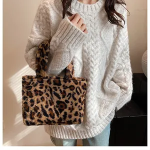 Close-up of leopard print faux fur tote bag paired with a beige cable knit sweater