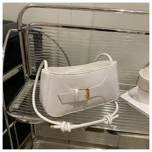 Détail d'un sac à main blanc avec boucle dorée sur un support en acrylique