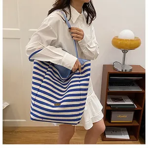 Vue détaillée du sac cabas en toile rayé bleu et blanc avec fine bandoulière
