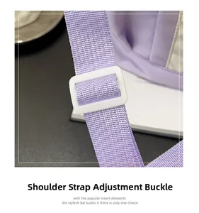 Detail of adjustable shoulder strap with white plastic buckle on light purple nylon bag