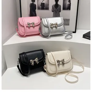 Gruppo di borse a tracolla colorate con eleganti fiocchi metallici su piedistalli