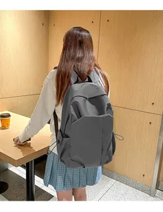Détail du sac à dos en toile gris foncé montrant la poche latérale et le tissu en nylon élégant