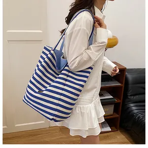 Détail d'un grand sac cabas en toile à rayures bleues et blanches avec boucle en métal