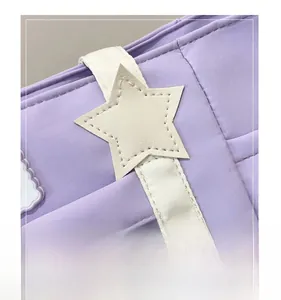 Detail view of purple canvas bag featuring white star patch and precise stitching work