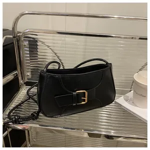 Détail du sac baguette noir en simili cuir avec boucle en métal et bandoulière nouée