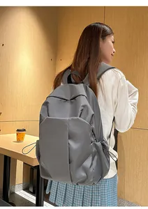 Détail du sac à dos en toile gris foncé avec poches à cordon et larges bretelles