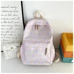 Dettaglio dello zaino rosa con graziosi motivi di gatti gialli e fiocchi blu decorativi