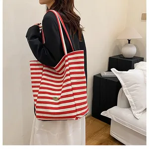 Détail du sac fourre-tout en tricot rayé rouge et blanc avec plaque métal et grande taille