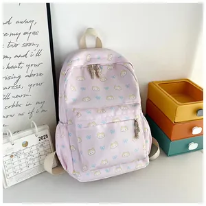 Dettaglio di uno zaino rosa con graziosi motivi a gatto e fiocchi blu decorativi