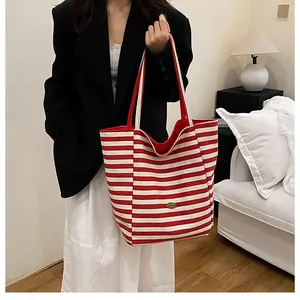 Détail du sac cabas à rayures rouges et blanches avec tissu robuste et logo en cuir