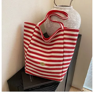 Gros plan détaillé d'un sac cabas à rayures rouges et blanches avec étiquette dorée