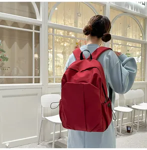 Vue arrière d'un sac à dos minimaliste en toile rouge vin avec bretelles rembourrées