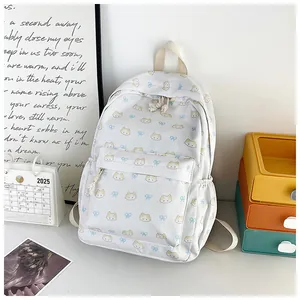 Dettaglio dello zaino bianco con stampe di gatti gialli e fiocchi blu decorativi