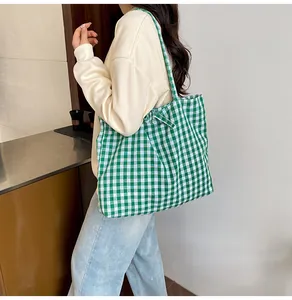 Detail of green and white checkered canvas tote bag showing large capacity and soft texture