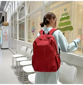 Mannequin portant un sac à dos en toile rouge avec des poches latérales à cordon