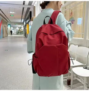 Sac à dos d'ordinateur rouge minimaliste en nylon présenté dans un décor lifestyle