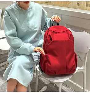 Détail d'un sac à dos rouge en toile à grande capacité avec poches latérales et design épuré