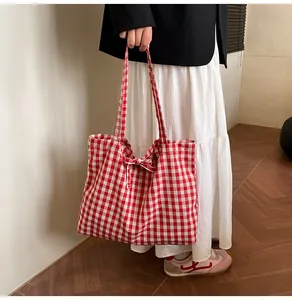 Detail of red and white checkered canvas tote bag with decorative bow and large capacity