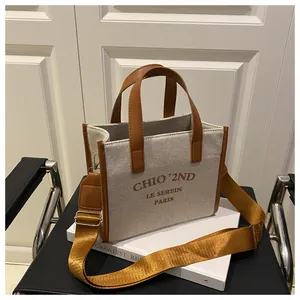 Détail du sac fourre-tout en toile avec garniture en cuir brun et bandoulière en nylon