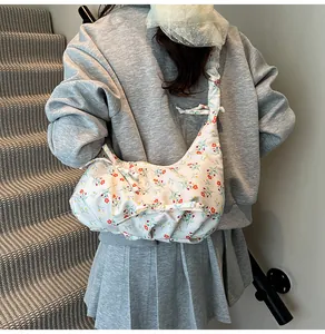 Floral print crescent shoulder bag with bow details worn over a casual outfit