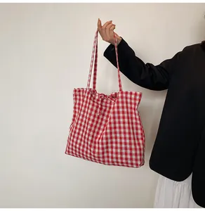 Detail of red and white gingham tote bag featuring a cute bow knot tie and soft cotton texture