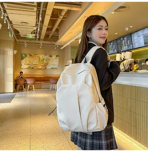 Détail du sac à dos en toile crème avec poches latérales et grand compartiment