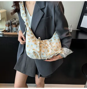 Floral print hobo bag with pleated strap and bow detail on model in casual office setting
