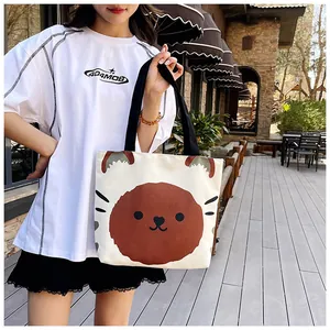 Detail of white canvas tote bag featuring large brown cartoon animal print and black handles