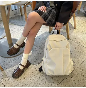 Vue détaillée du grand sac à dos en toile beige avec poches latérales à cordon pratiques