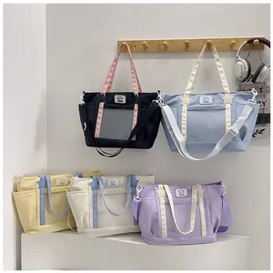 Multiple colorful tote bags with transparent PVC front pockets and star-shaped buckles