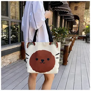 Close-up of a large beige canvas tote bag featuring a cute brown bear cartoon print
