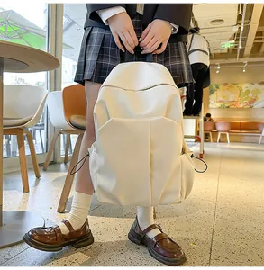 Détail d'un sac à dos crème avec poches latérales élastiques et design à plis verticaux