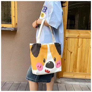 Detail of canvas tote bag featuring a cute cartoon corgi print and dual handles