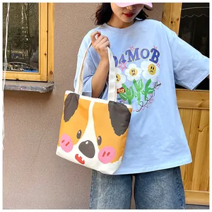 Close-up of a cream canvas tote bag with a cute cartoon corgi dog face print