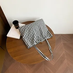 Classic black and white gingham canvas tote bag shown on a wooden table in a lifestyle setting