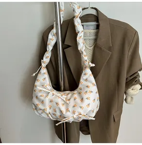 Detail of floral dumpling bag with orange blossom patterns and ribbon bow decorations