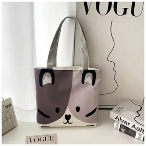 Detail of canvas tote bag showing cute cartoon cat face print and grey webbed handles