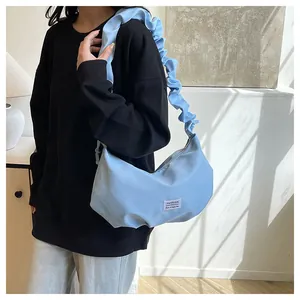 Détail du sac nuage bleu clair avec bandoulière plissée et étiquette Fashion