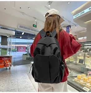 Détail d'un sac à dos noir minimaliste en nylon avec poche latérale à cordon pratique