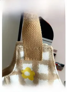 Detail view of canvas bag with brown checkerboard pattern and yellow flower prints