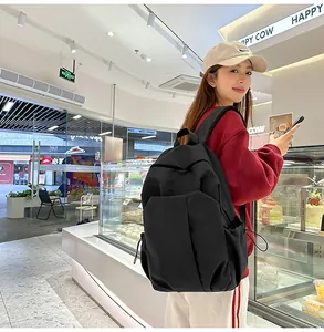 Détail du sac à dos noir en nylon grande capacité avec poches latérales à cordon et bretelles