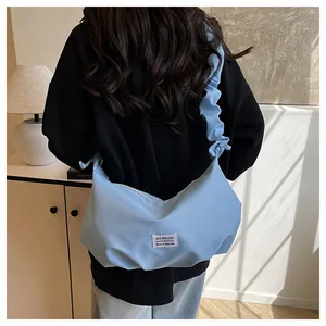 Détail du sac nuage bleu clair avec étiquette FASHION et bandoulière froncée