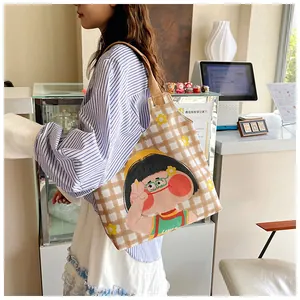 Detail of cartoon girl illustration on checkered canvas tote bag with brown fabric handles