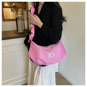 Sac baguette rose avec bandoulière plissée et étiquette textile de mode stylée
