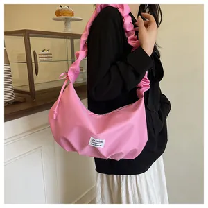 Détail du sac baguette rose vif avec bandoulière plissée et étiquette FASHION