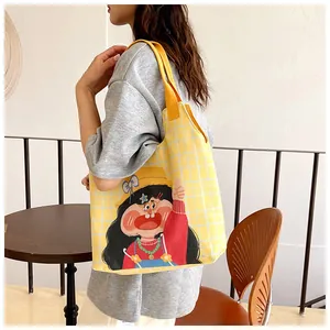 Detail of yellow checkered canvas tote bag featuring vibrant cartoon girl illustration
