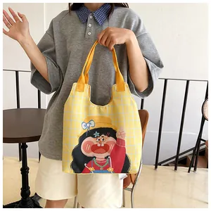 Close-up of yellow checkered canvas tote bag featuring cute cartoon girl illustration